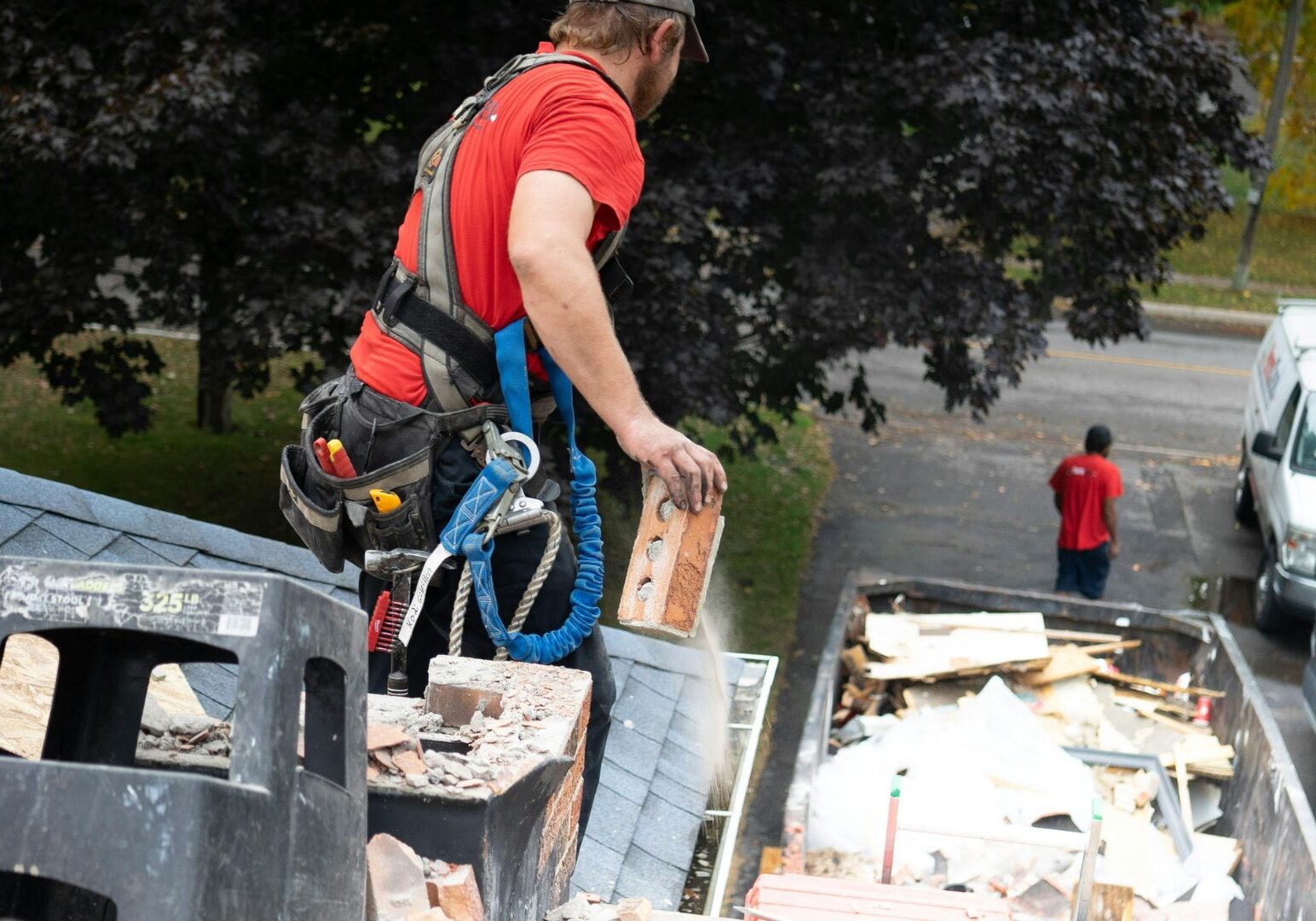 Construction Worker on Roof Removing Debris Construction Worker on Roof Removing Debris